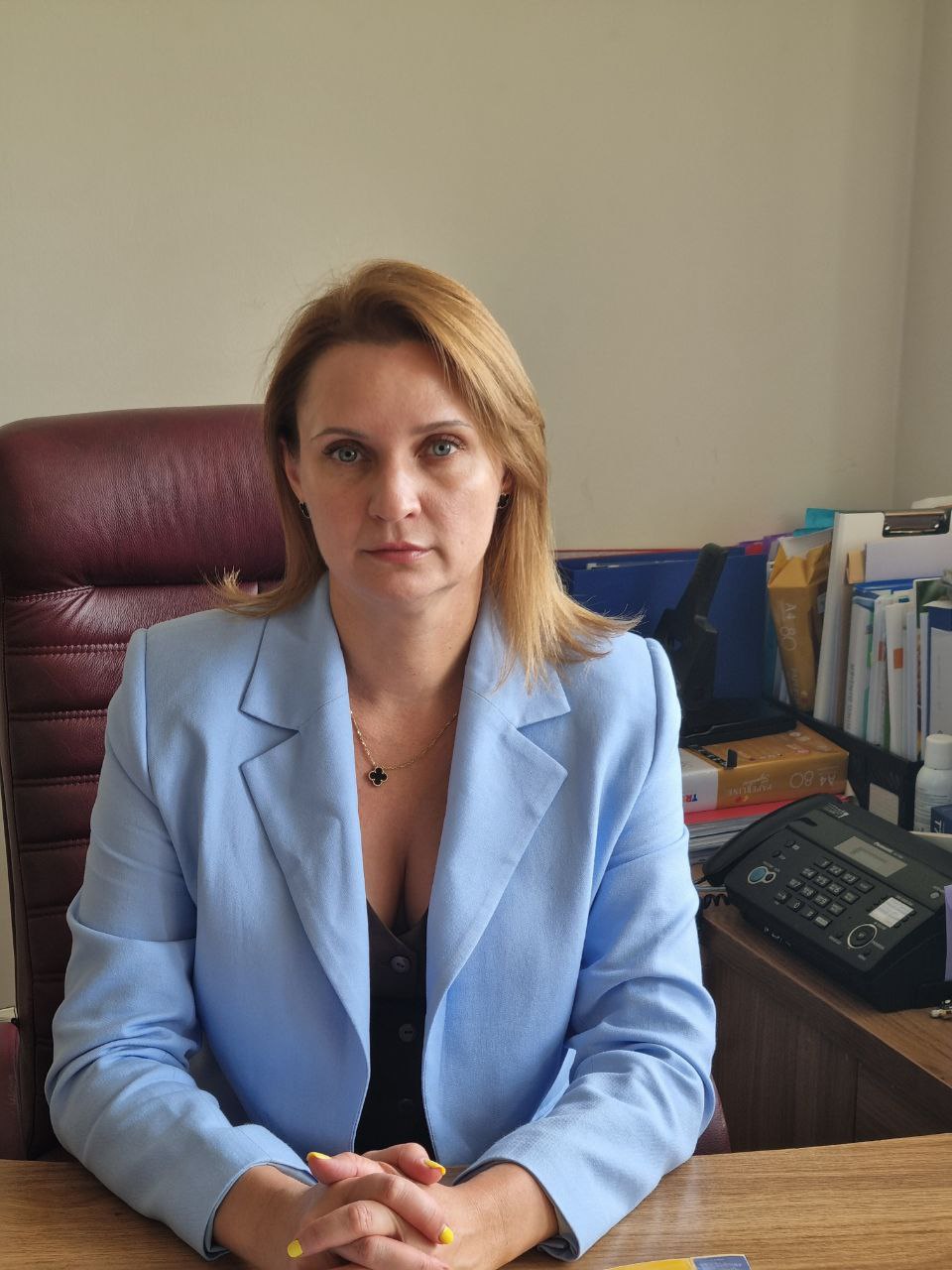 Portrait of Tatiana Rotari sitting at a desk with documents and a pen